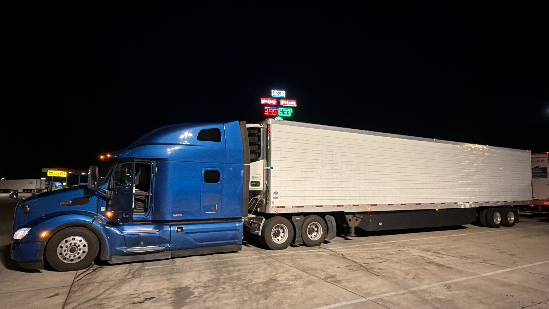 JTM’s blue Peterbilt with a refrigerated trailer parked at night